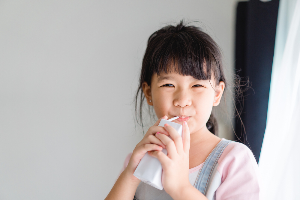 Young girl drinking juice box