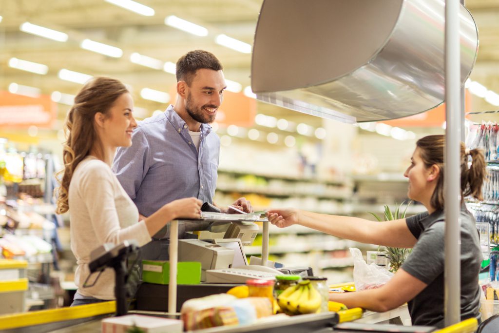 attractive couple grocery shopping - they are buying Yogurt 